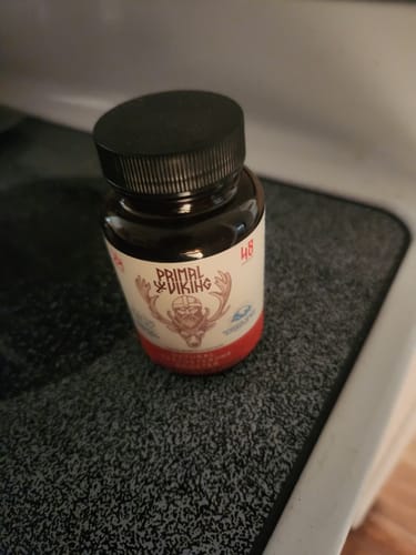 Customer's Primal Testosterone Booster supplement bottle sitting on a grey countertop.