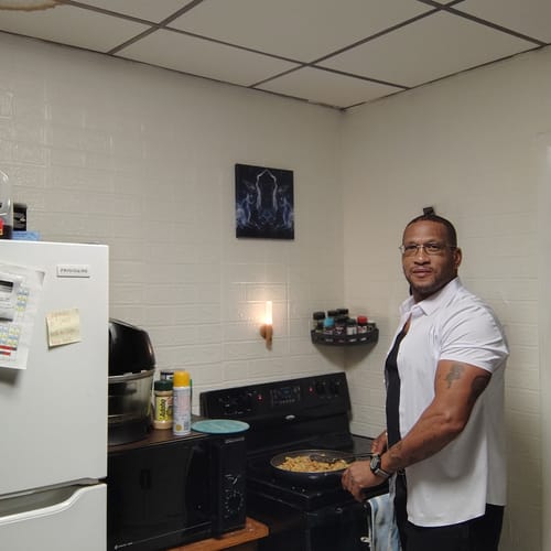Customer's Primal Testosterone Booster reviewer cooking food on a stove in a kitchen.