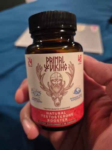 Customer holding a brown bottle of Primal Reindeer Testosterone Support.